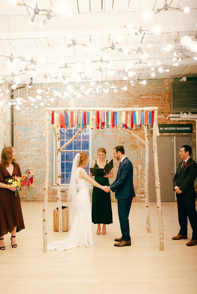 Mass MoCA wedding ceremony with colorful decorations and smiling guests