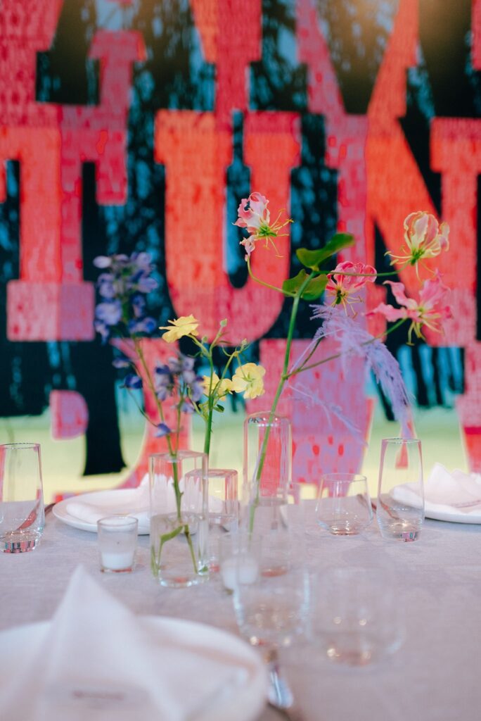 Brightly colored background with place settings and table flowers in foreground