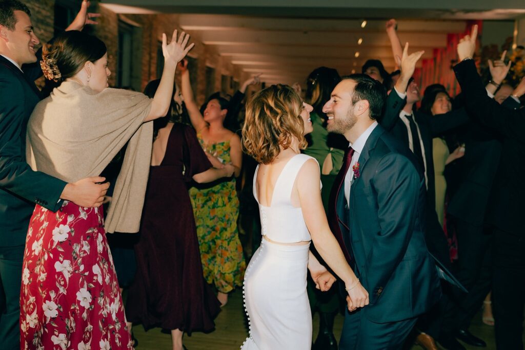 Mass MoCA wedding reception with guests dancing and throwing their hands in the air
