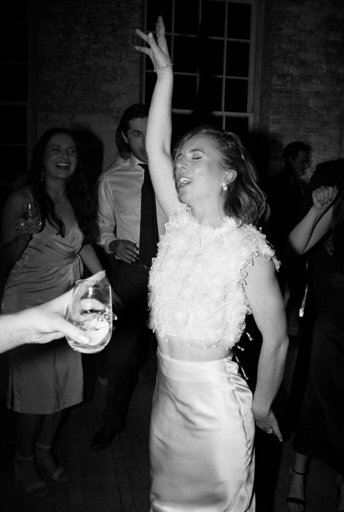 Bride poses and sings during her wedding reception at Mass MoCA, captured on film in black and white