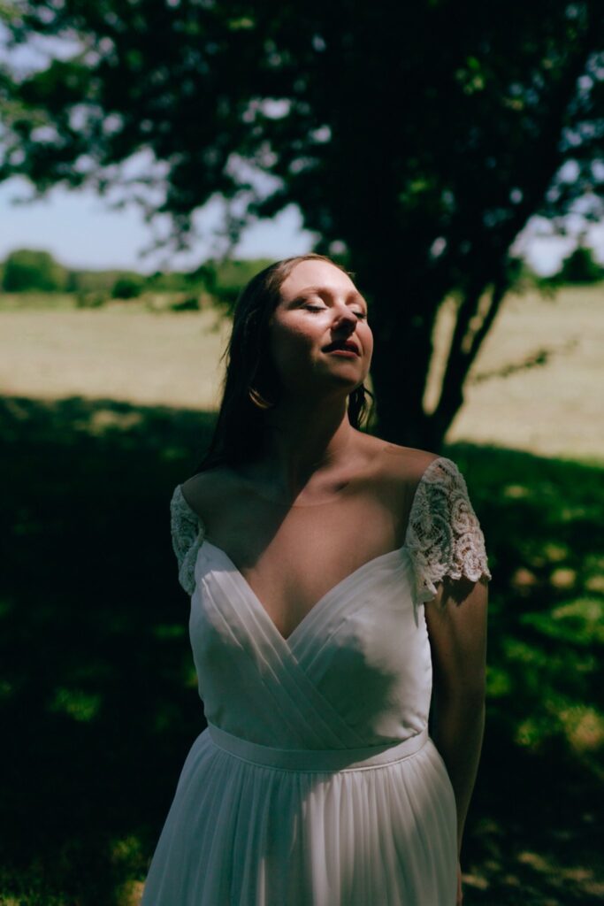 a bride gazes at the sun with a shadow on her face