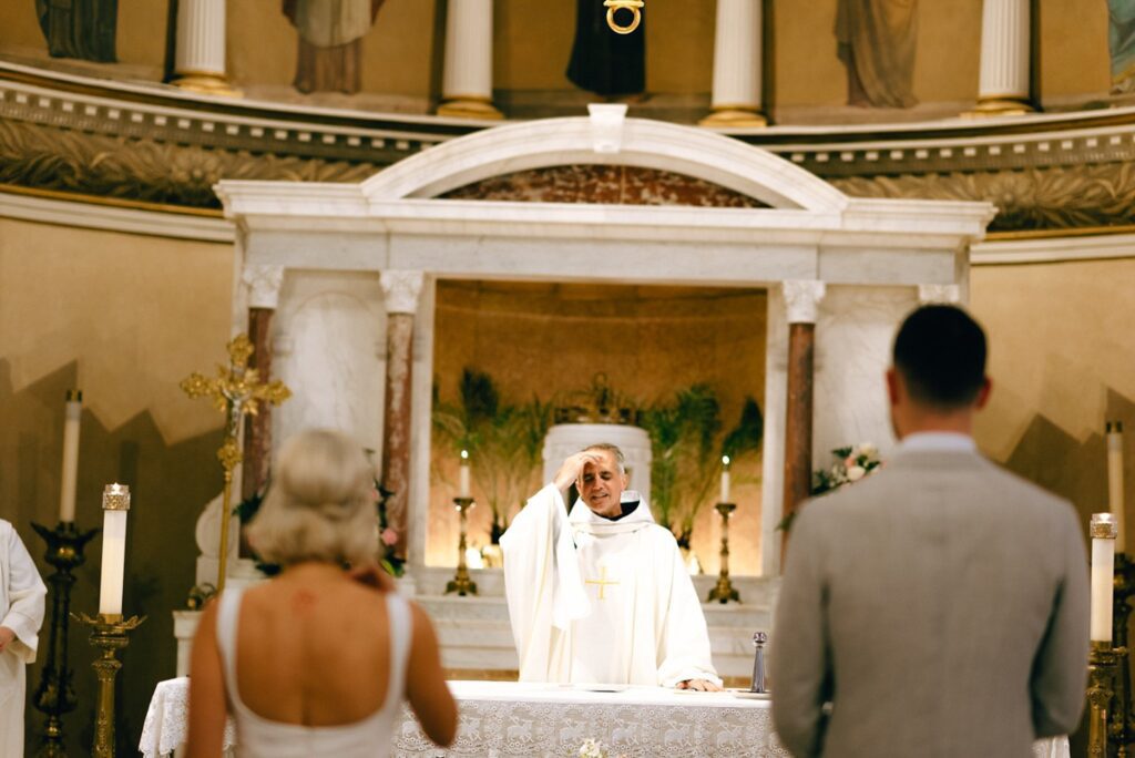 a priest blesses a couple during their wedding in Boston