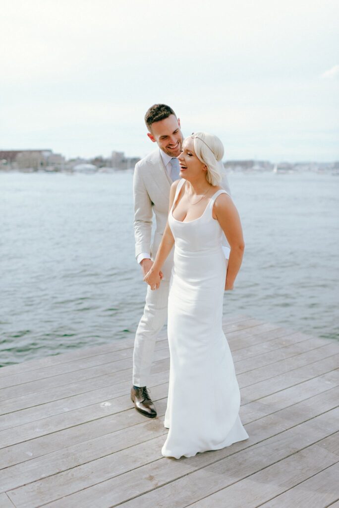 a couple laughs during their wedding portraits in Boston