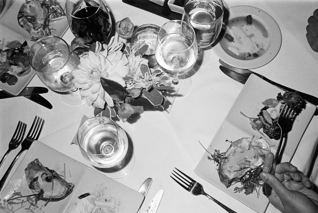 Elegant black and white film photograph of a wedding table setting, emphasizing timeless details and sophisticated design.