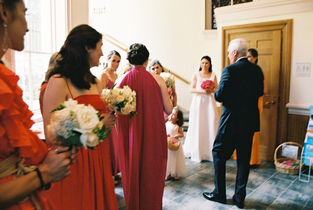Film photograph capturing the wedding party gathering in the church wings before the ceremony, a moment of anticipation and camaraderie.