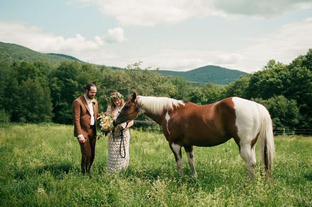 a couple stands with a horse on a private estate in Vermont