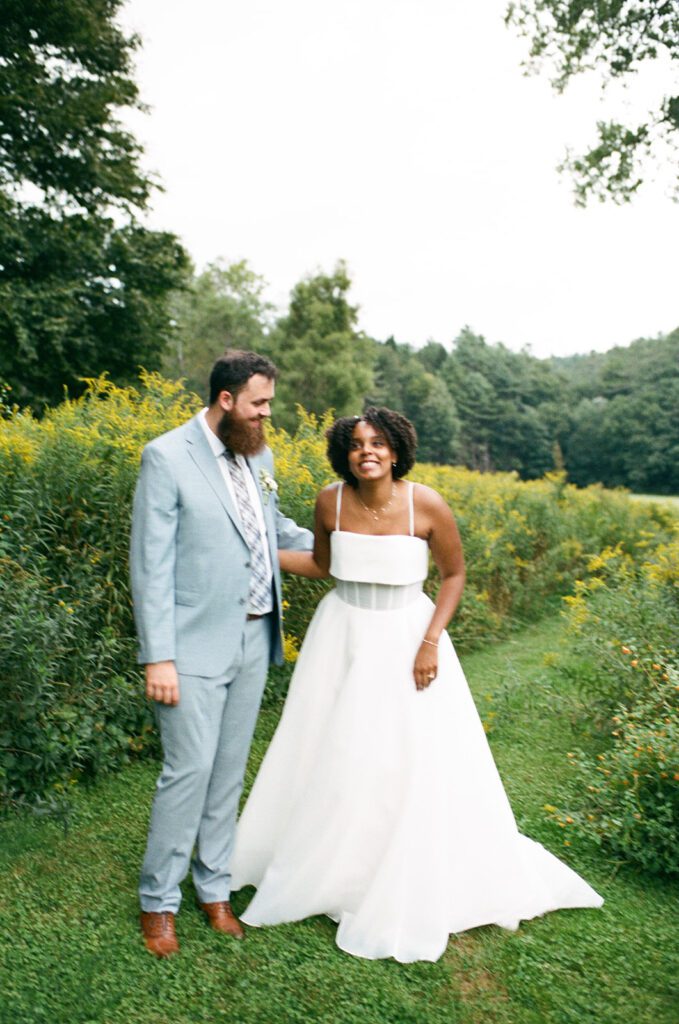 a couple stands in a field in Quechee, Vermont