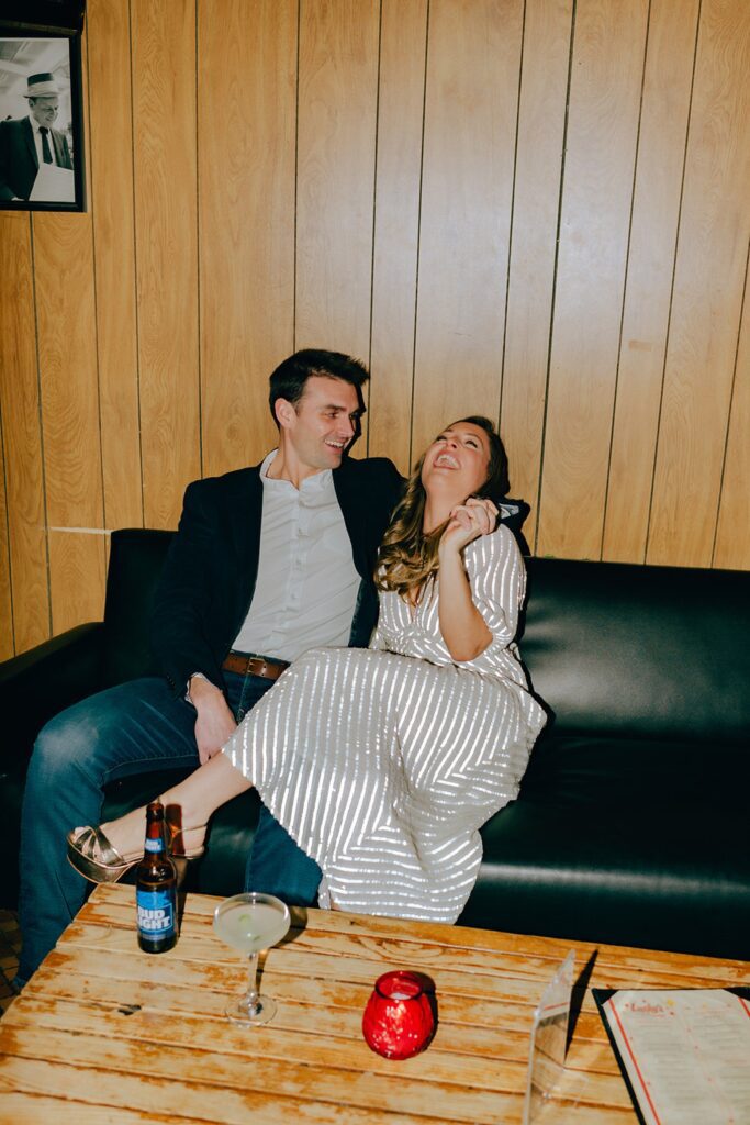 a couple sitting down and laughing at their favorite bar