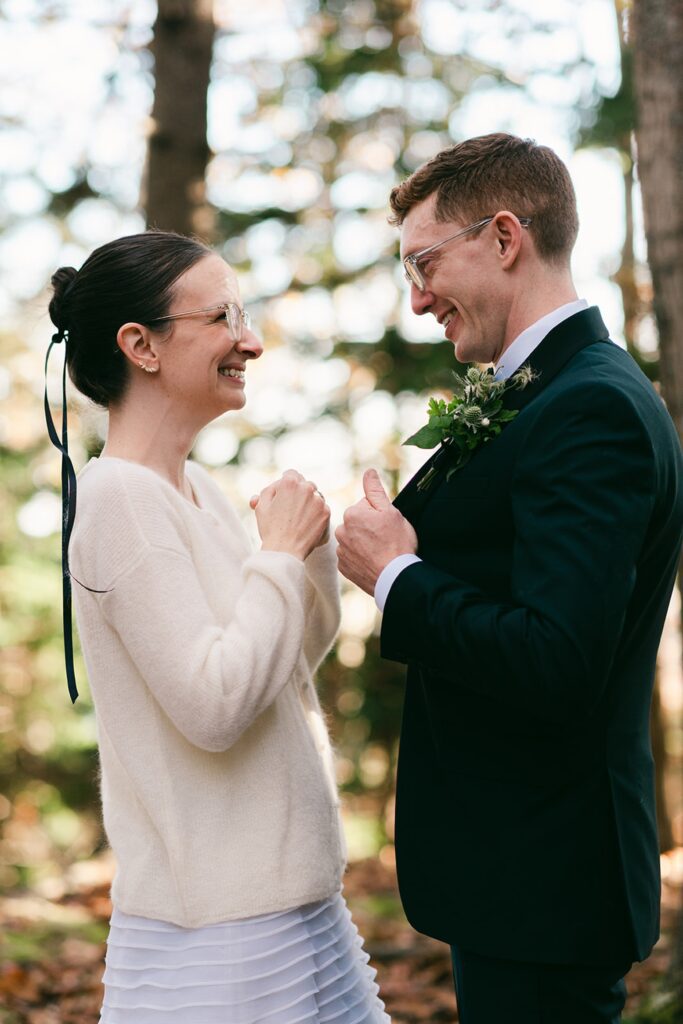 Bride and groom smile at each other in candid wedding photograph