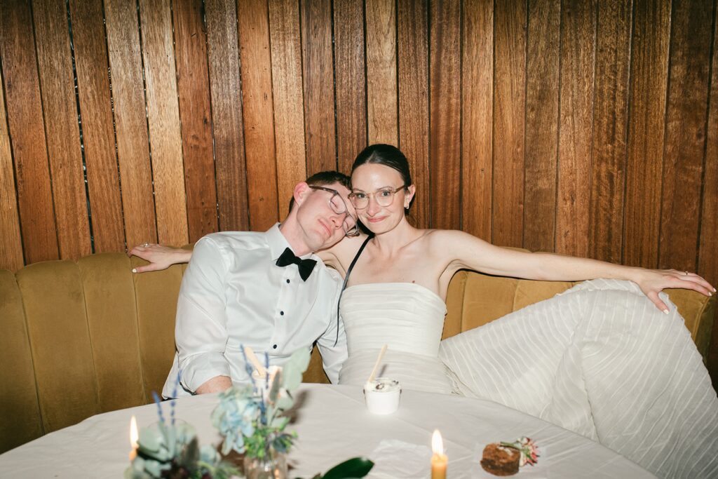 Film photograph of bride and groom sitting together, satisfied and exhausted from a beautiful reception