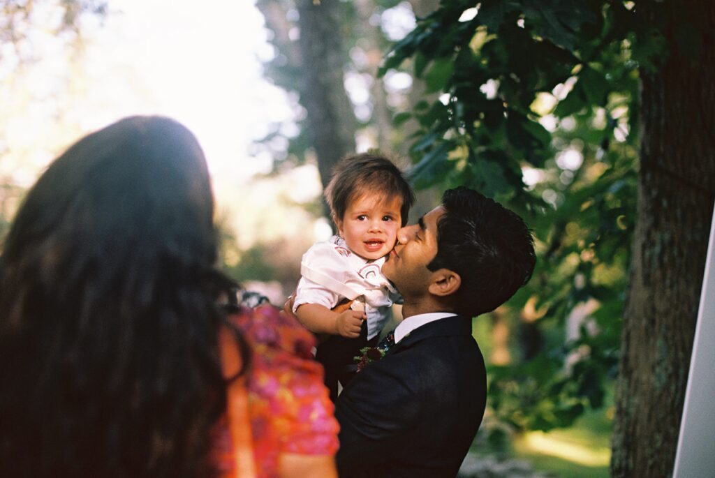 a father cuddles with his child at a wedding