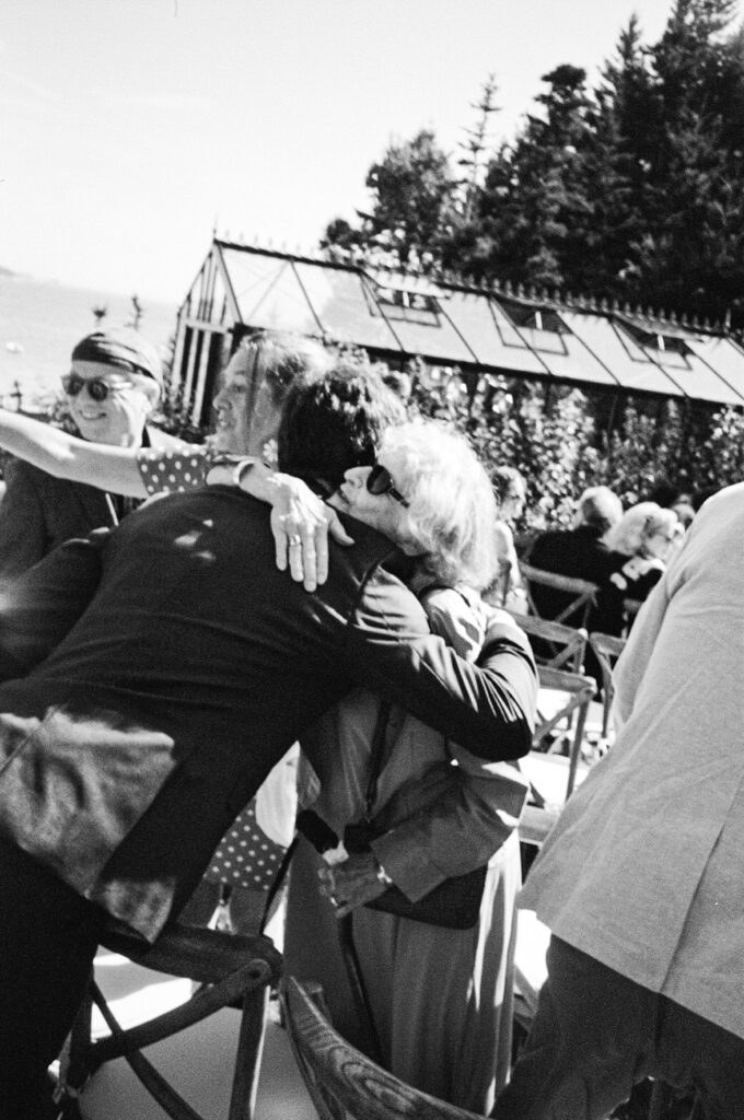 two guests at a wedding ceremony hug