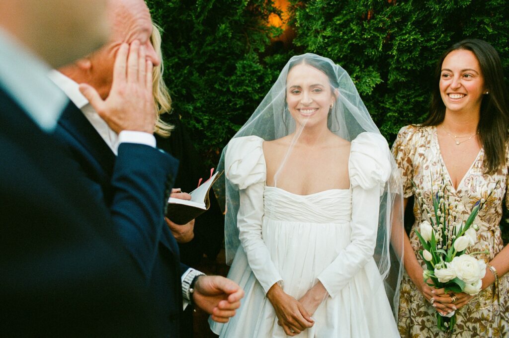 a bride smiles during her wedding ceremony