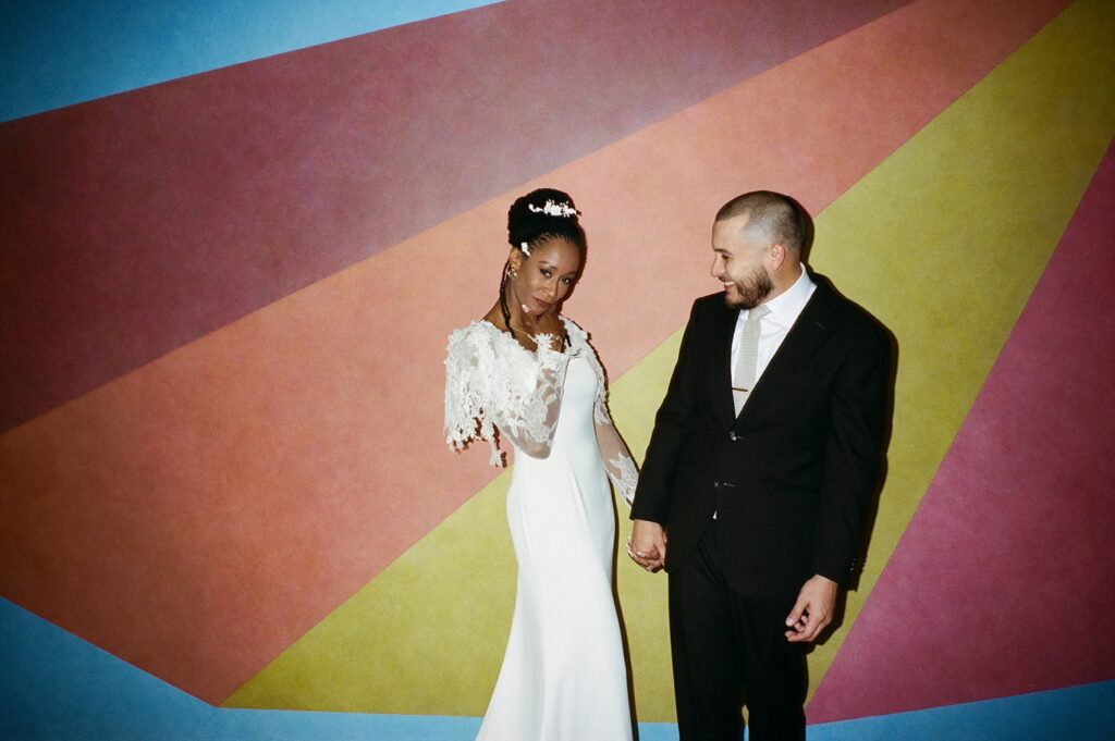 a couple poses for fun wedding portraits in an art museum