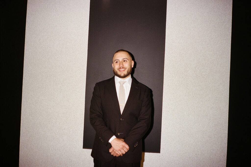 a groom portrait in front of art on a wedding day