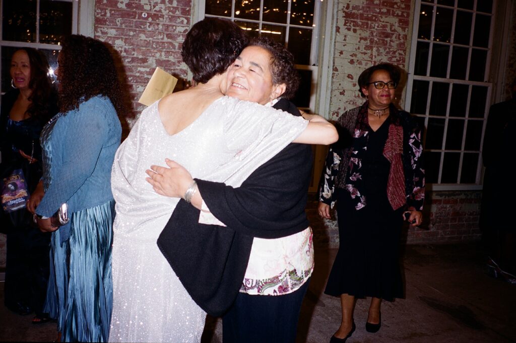 two guests at a wedding embrace