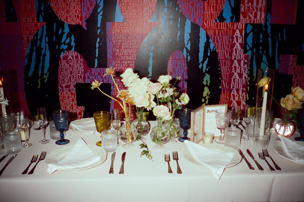 neutral wedding florals in front of a colorful mural