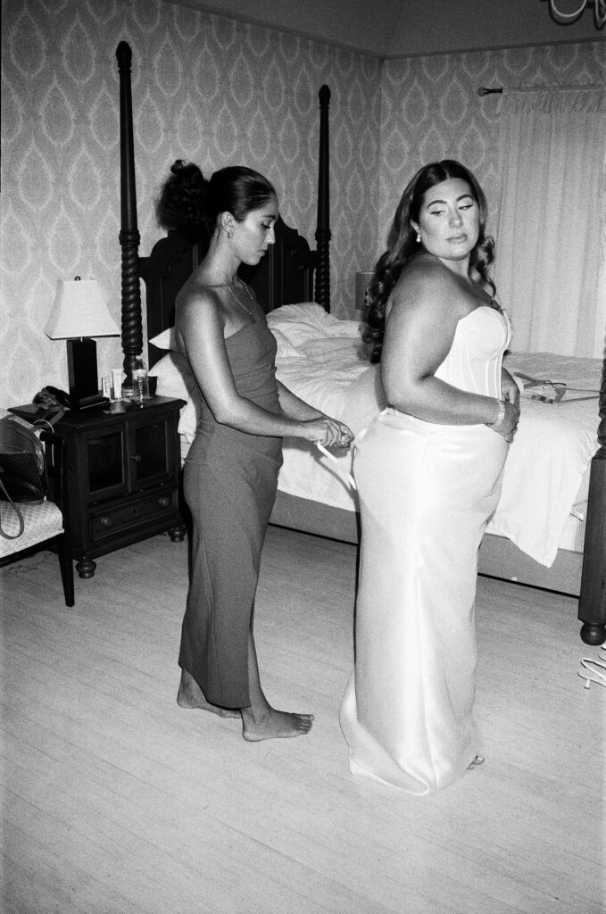 a bride gets into her custom wedding gown